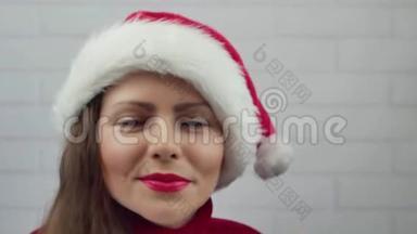 祝<strong>2018</strong>年<strong>新年</strong>快乐。 圣诞老人女孩用口红在<strong>2018</strong>年的玻璃单词上写字。 戴着圣诞帽的漂亮女孩在发信息。